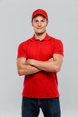Young delivery man smiling while posing with arms crossed