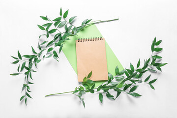 Composition with blank notebook, sheet of paper and plant branches on white background