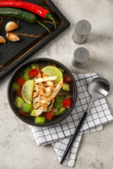 Composition with tasty Sopa de Lima soup on light background