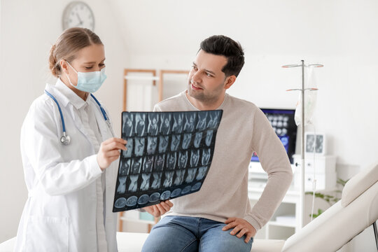 Female doctor showing x-ray scan to patient in clinic