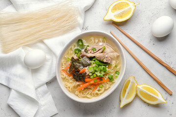 Composition with tasty Chinese soup on light background