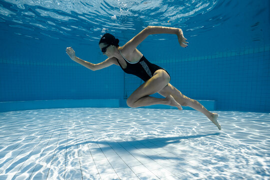 Young sporty woman running underwater.