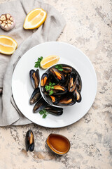 Plate with raw mussels and lemon on color background