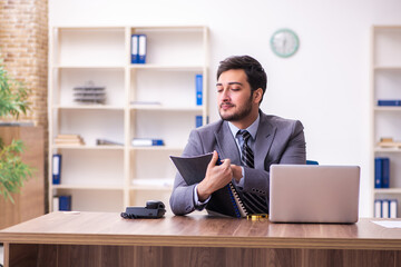 Young handsome businessman employee working in the office