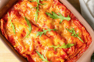Baking dish with tasty tomato lasagna on table, closeup