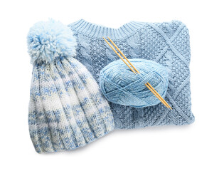 Yarn with knitting needles, hat and sweater on white background