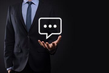 Businessman holding a message icon, bubble talk notification sign in his hands. Chat icon, sms icon, comments icon, speech bubbles