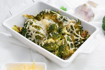 Baking dish with tasty broccoli and cheese on table