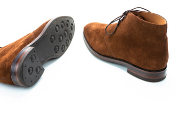 Closeup of Pair of Male Brown Suede Chukka Boots Placed Randomly Together On White Background.