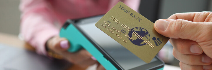 Man applying credit bank card to pos terminal closeup