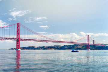 Portugal Travel Ideas. One Blue Sailing Boat With Group of Tourist on Tagus River Under 25th of April Bridge in Lisbon