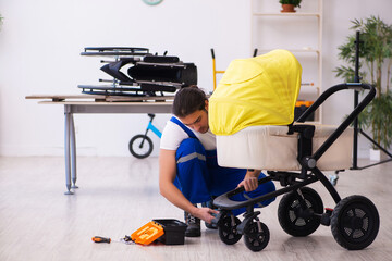 Young male repairer repairing perambulator indoors