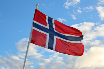 Norwegian flag behind a ferry in Norway.