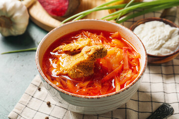 Bowl of tasty borscht on table