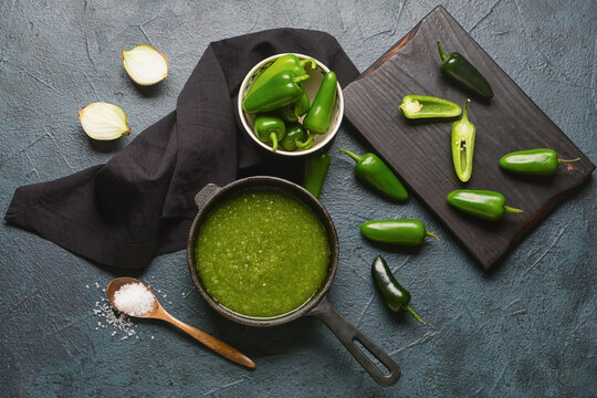 Frying Pan With Tomatillo Salsa Verde Sauce And Ingredients On Dark Background