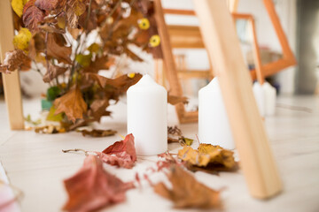 Close up of autumn arrangement with three white candles