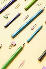 Pencils with paper clips on color background