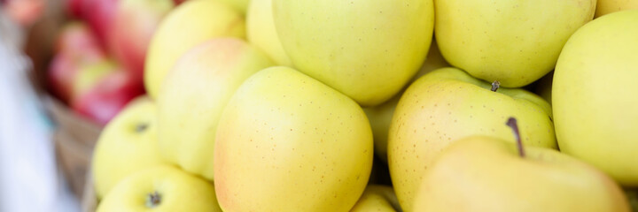 Many yellow and red apples lying in shop window closeup