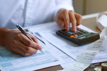 Man hand filling US tax form. tax form us business income office Financial document. Tax time.Tax...