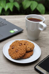 Close up of cookies on plate and a cup of tea