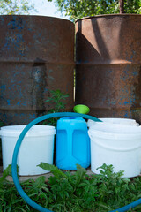 Barrels of water. Metal container for storing water. Buckets and watering can for watering plants. Agricultural tool.