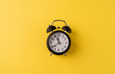 White retro alarm clock isolated on yellow background with copy space