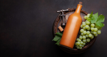 Wine bottle and white grape on old barrel