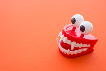 Vampire chattering teeth toy on red background with copy space. Halloween ghost festival or trick...