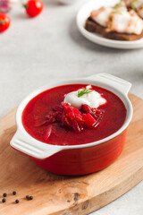 Delicious fresh red borscht, dark bread with lard and salt on kitchen table. 