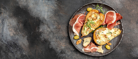 Appetizer with pear baked with blue cheese, nuts and honey, prosciutto. Summer snacks. Pear appetizer with jamon, Long banner format. top view.