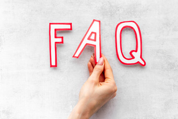 Hands with faq - frequently asked questions - made of paper