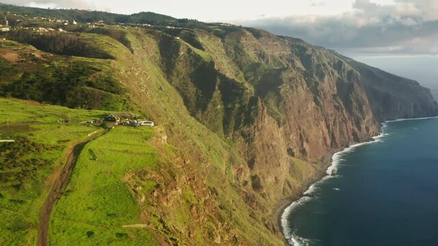 Madeira Islands, Portugal. The cozy cottage on the tip of the island, above sea level. Aerial view of a settlement dominating the top of the cliff. High quality 4k footage