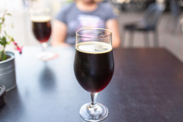 two glass of dark beer stands on a table in a bar or pub.Close-up.