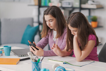 Obraz premium Cute schoolgirls doing homework together