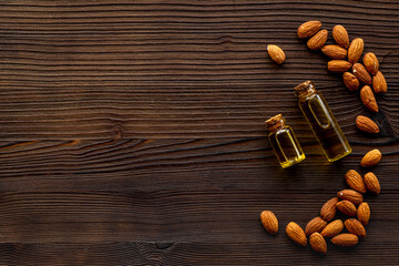 Almond nut oil in glass bottle with almond nuts. Extra virgin essence oil