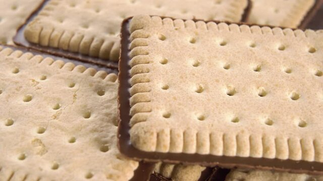 Crispy biscuits with a chocolate layer close up rotates. Macro. Patterned surface. Selective focus