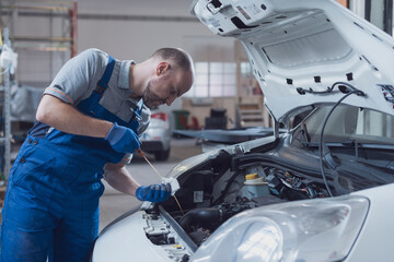 Mechanic checking a car's oil level and quality