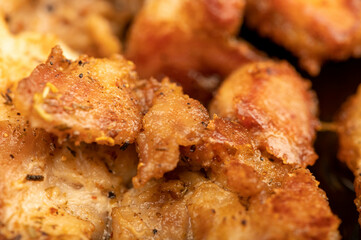 Fried pieces of meat in a frying pan, close-up, selective focus.