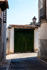Green painted wooden doorway in the historic center of a village. Chinchon, Spain