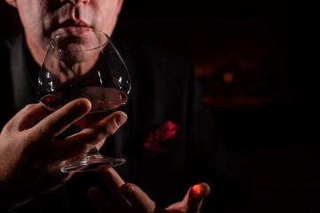 Man drinking whiskey by the fireplace.