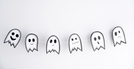Banner Halloween garland of paper ghost on a white background craft with their hands with children.