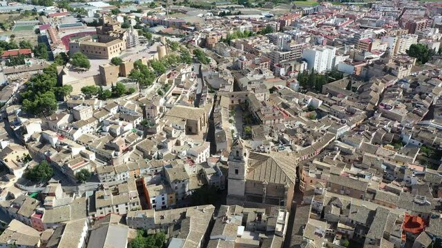 Aerial view of fortified castle and Basilica of Vera Cruz on hill dominating residential areas of Spanish town of Caravaca de la Cruz on summer day. High quality 4k footage