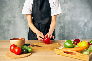 Cook woman on the kitchen cutting vegetables salad diet