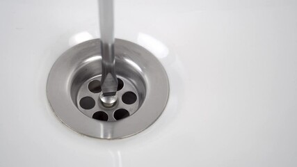 Plumbing the sink with a screwdriver. Screwing in and fixing the stainless steel fastener. Repair of a drain with a leak. Close up. Household and professional service concept