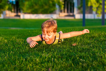 The child spends time in the park, he is very happy. Have fun and enjoy a summer day. Walking and recreation.