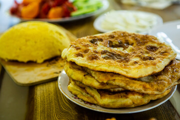 image with the hands of a lady cooking traditional Romanian fried pies with cheese in traditional clothes.