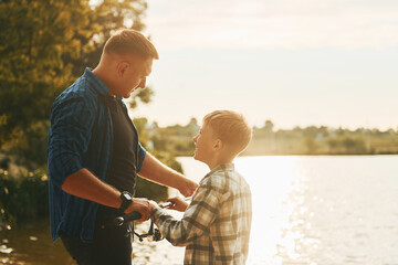 Father and son on fishing together outdoors at summertime