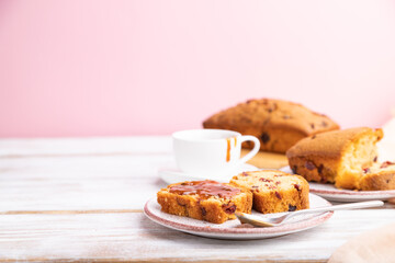 Homemade cake with raisins, almonds, soft caramel on a white and pink background.  Side view, copy space.