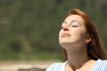 Fototapeta na wymiar Woman relaxing breathing fresh air a sunny day