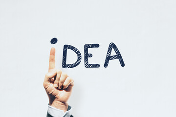 Hand pointing up replacing letter i in idea word on white background. Inspiration and creativity concept.
